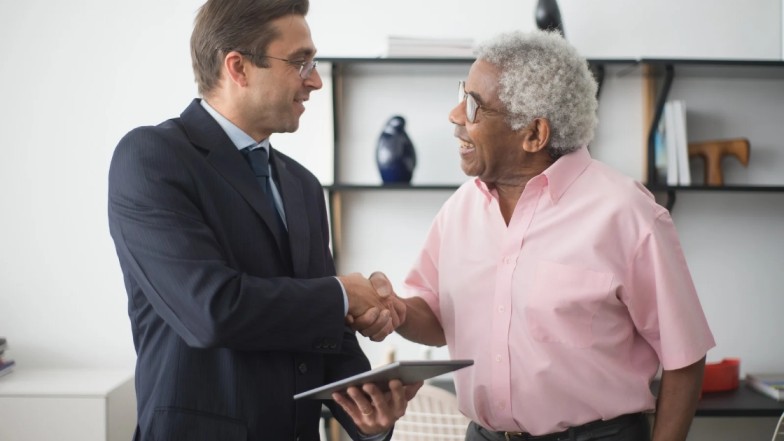Personal injury lawyer handshaking with client after winning the case.