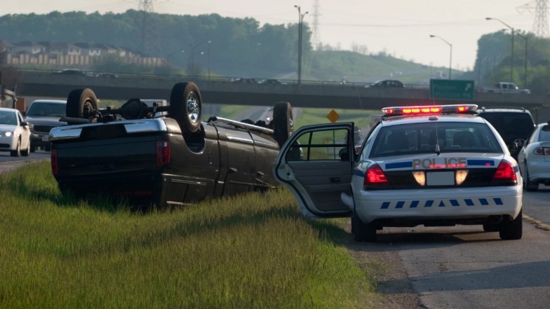 Police vehicle at accident scene representing legal requirement of filing report
